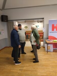 Tre personer står och diskuterar